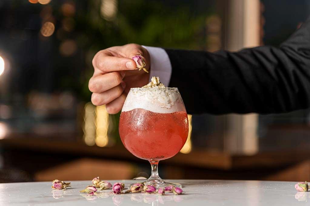 Aleph Doha Residences, Curio Collection By Hilton Ресторан фото A bartender adding a rose petal to a cocktail